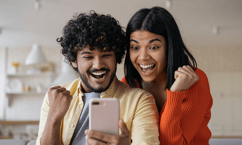 Two people look at the screen and cheer